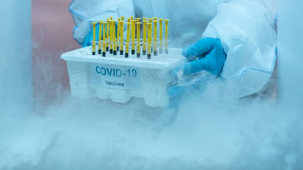 파란 장갑과 보호장비를 갖춘 의료진이 병원 코로나19구역 냉동 창고에 보관 중인 백신 박스를 제거하고 있다.